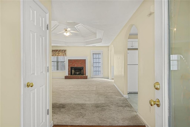 corridor featuring carpet, arched walkways, and baseboards