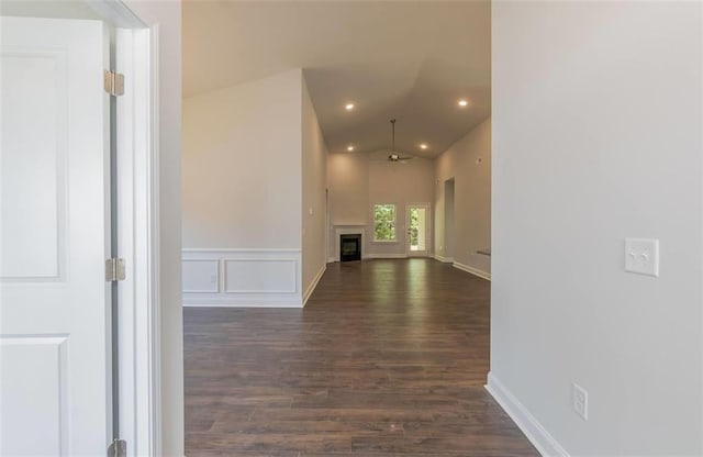 hall with dark wood-style floors, a wainscoted wall, vaulted ceiling, a decorative wall, and recessed lighting