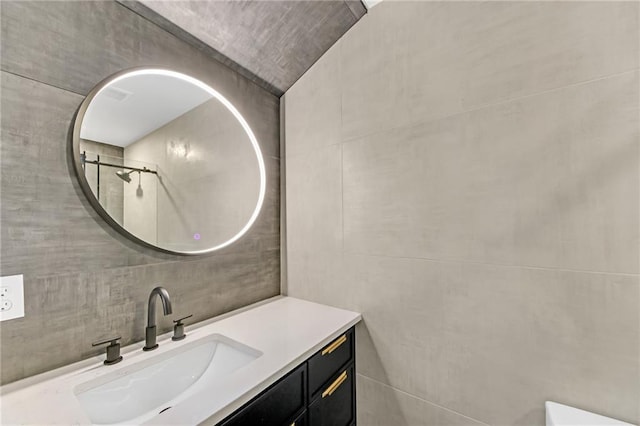 bathroom with vanity and tile walls