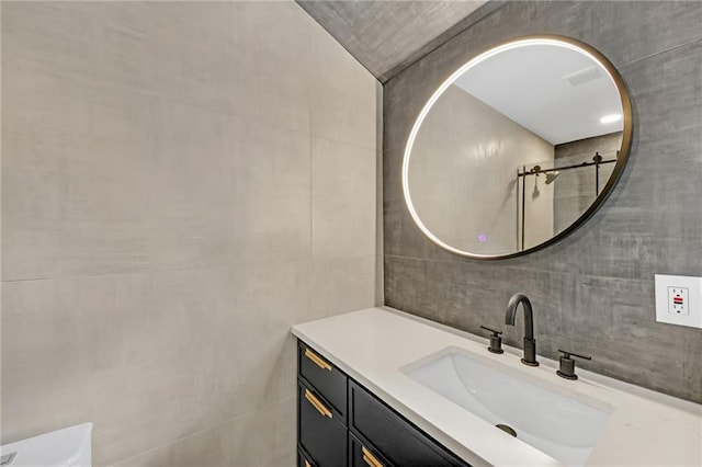 bathroom featuring vanity and tile walls