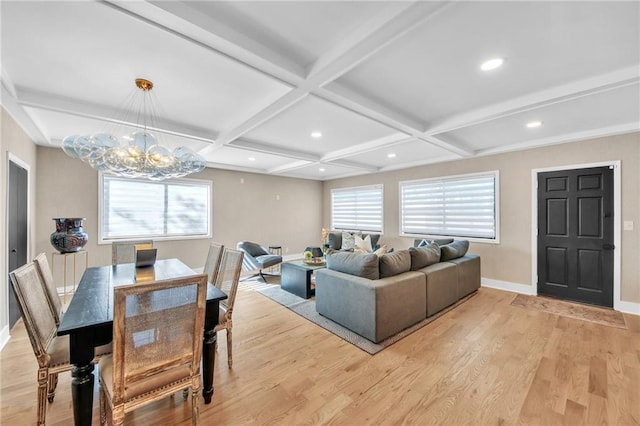 living room featuring beam ceiling, an inviting chandelier, light hardwood / wood-style flooring, and coffered ceiling