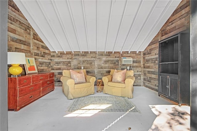 sitting room featuring a wall mounted air conditioner, lofted ceiling, and wooden walls