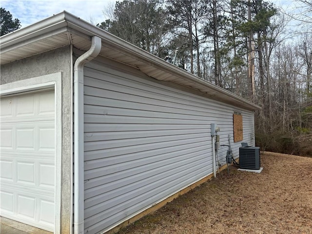 view of side of home featuring a garage and central AC