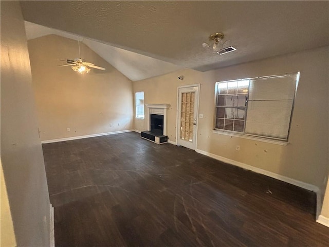 unfurnished living room featuring dark wood-type flooring, ceiling fan, vaulted ceiling, and a textured ceiling