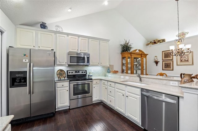 kitchen featuring sink, decorative light fixtures, dark hardwood / wood-style flooring, white cabinetry, and stainless steel appliances