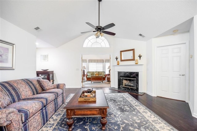 living room featuring a fireplace, dark hardwood / wood-style floors, ceiling fan, and lofted ceiling