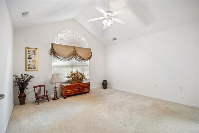 spare room featuring light carpet, ceiling fan, and vaulted ceiling