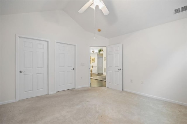 unfurnished bedroom featuring light colored carpet, high vaulted ceiling, and ceiling fan