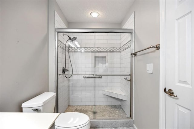 bathroom with toilet, an enclosed shower, a textured ceiling, and vanity