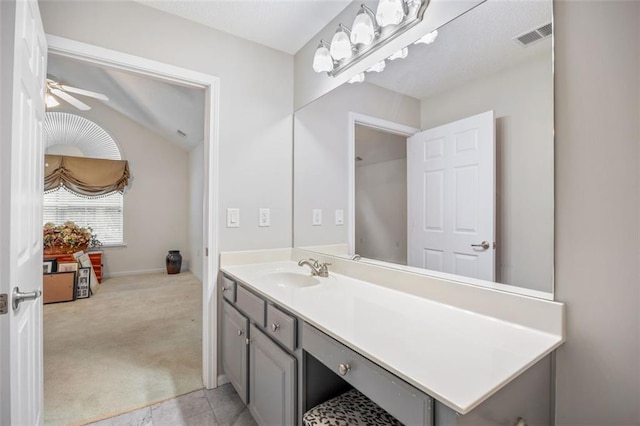 bathroom with vanity, ceiling fan, and vaulted ceiling