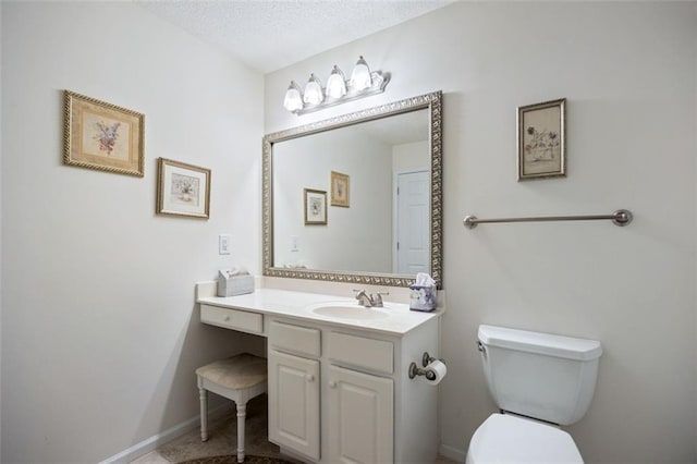 bathroom with vanity, a textured ceiling, and toilet