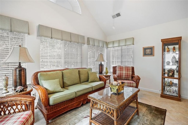 living room with light tile patterned floors and high vaulted ceiling