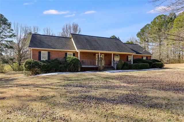 ranch-style home featuring a front lawn and covered porch