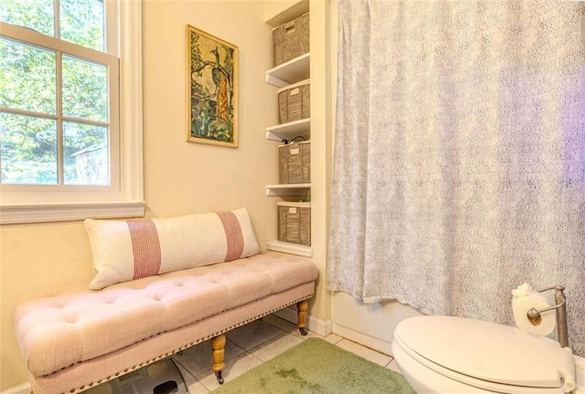 bathroom with a wealth of natural light, tile patterned floors, and toilet