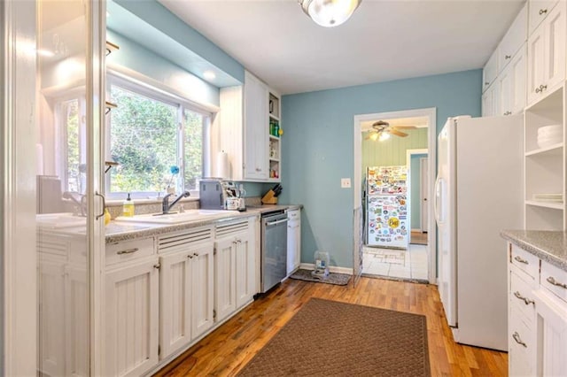 kitchen with sink, light hardwood / wood-style flooring, white refrigerator, stainless steel dishwasher, and white cabinets