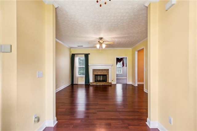 99 Rainwater Ln, Dallas, GA 30157 - unfurnished living room with ceiling fan, dark wood-type flooring, ornamental molding, a fireplace with raised hearth, and baseboards