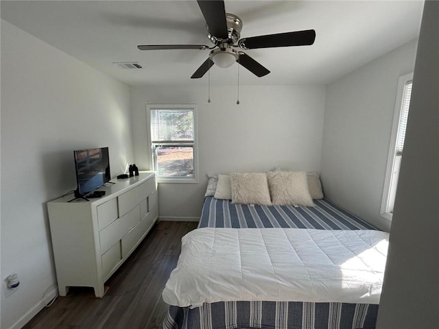 bedroom featuring dark wood-style floors, a ceiling fan, visible vents, and baseboards