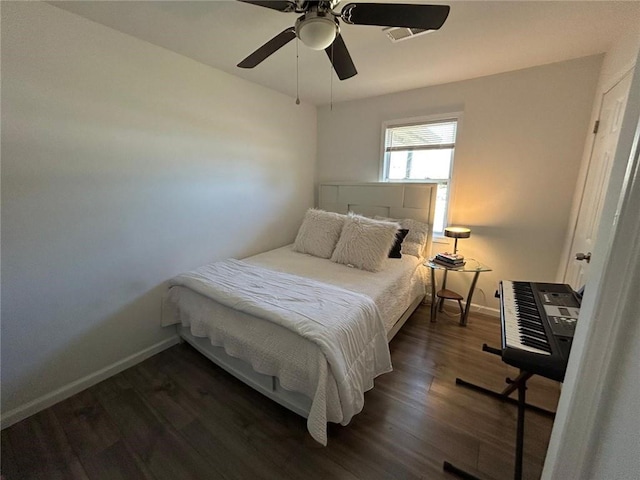 bedroom with ceiling fan, dark wood finished floors, and baseboards