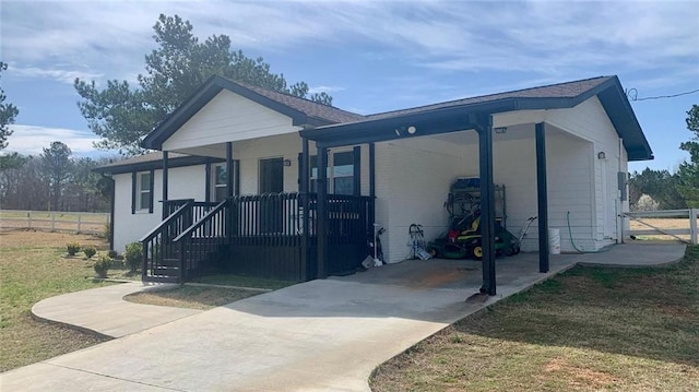 view of front of home featuring covered porch, driveway, a carport, and fence