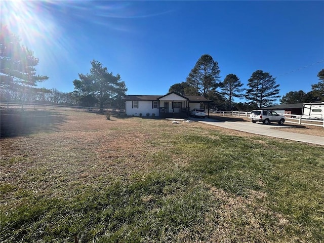 view of yard with fence and concrete driveway