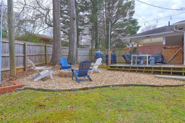 view of yard featuring a deck and a fire pit