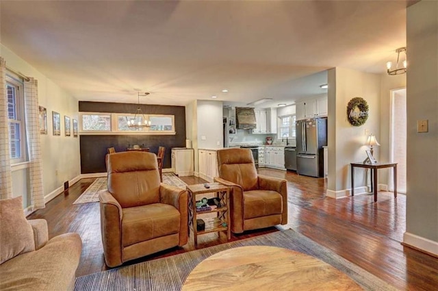 living room with sink, wood-type flooring, and a chandelier