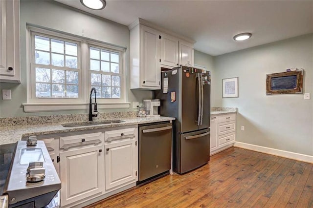 kitchen featuring white cabinetry, sink, hardwood / wood-style flooring, and stainless steel appliances