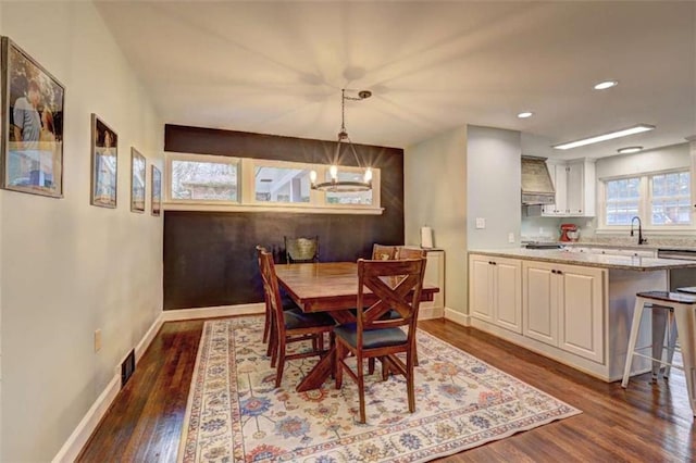 dining room featuring sink, a notable chandelier, and dark hardwood / wood-style flooring