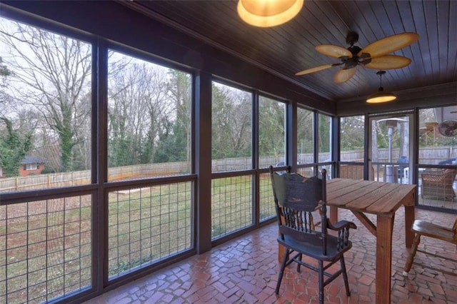 sunroom / solarium with wood ceiling, a wealth of natural light, and ceiling fan