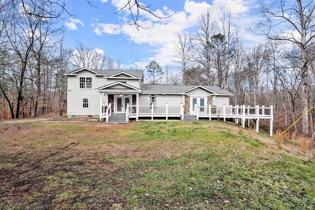 view of front of house with a wooden deck and a front yard