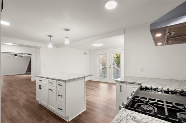 kitchen with white cabinets, decorative light fixtures, and light stone countertops