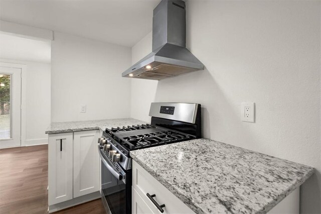 kitchen with white cabinets, wall chimney exhaust hood, and stainless steel range with gas stovetop