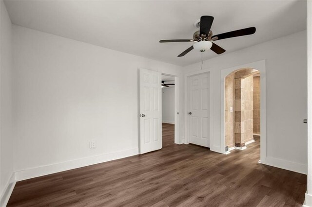 unfurnished bedroom with connected bathroom, dark hardwood / wood-style floors, and ceiling fan