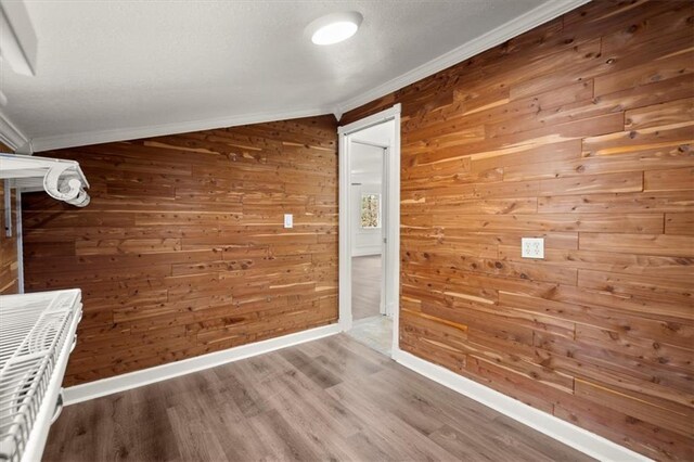 hall with wood-type flooring, crown molding, and wooden walls