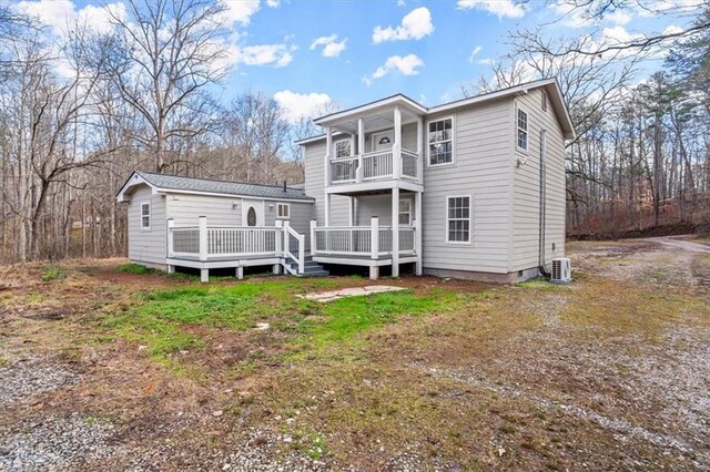 rear view of house featuring a balcony and a deck