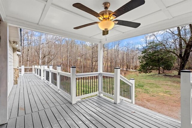 wooden deck with ceiling fan and a lawn