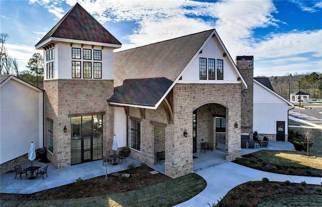 2808 Turnwater St, Hoschton, GA 30548 - view of front of property featuring a patio, a chimney, stone siding, brick siding, and a shingled roof