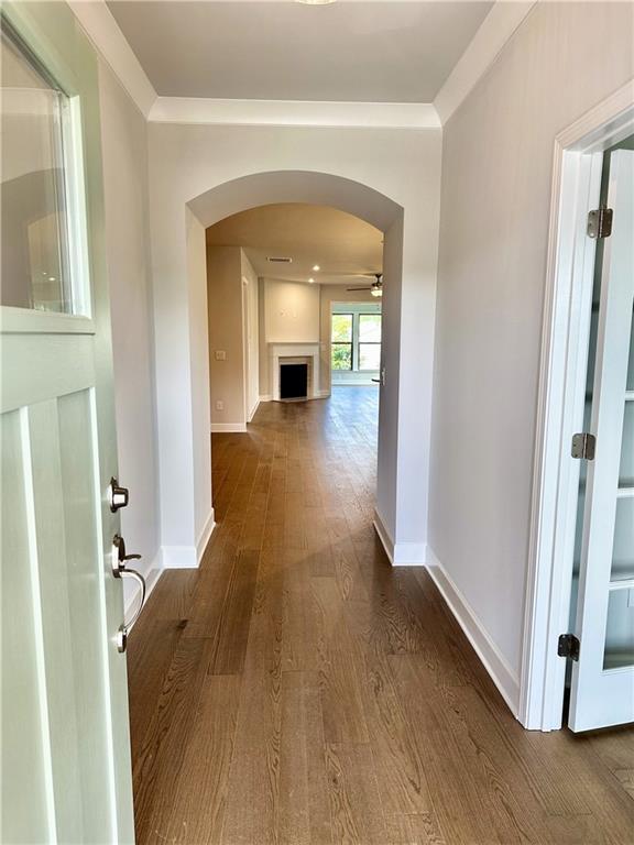 2808 Turnwater St, Hoschton, GA 30548 - hallway featuring dark wood finished floors and arched walkways