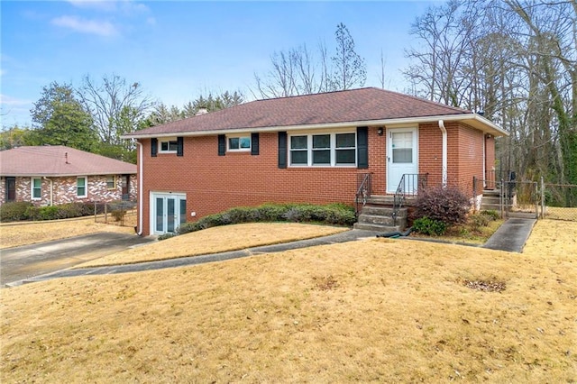 single story home with fence, a front lawn, and brick siding