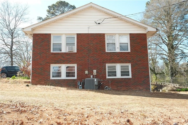 rear view of house with central AC unit and brick siding