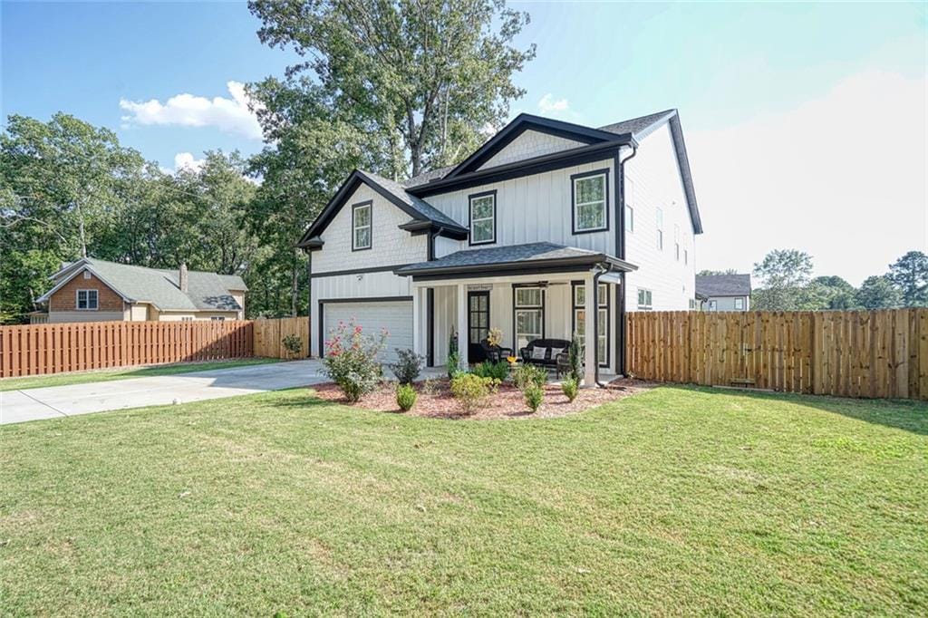 view of property with a porch, a garage, and a front yard