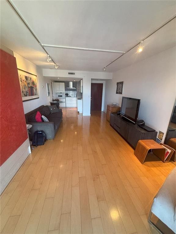 living room with track lighting and light wood-type flooring