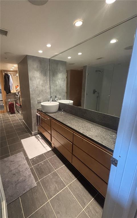 bathroom featuring vanity, tile patterned flooring, and a shower