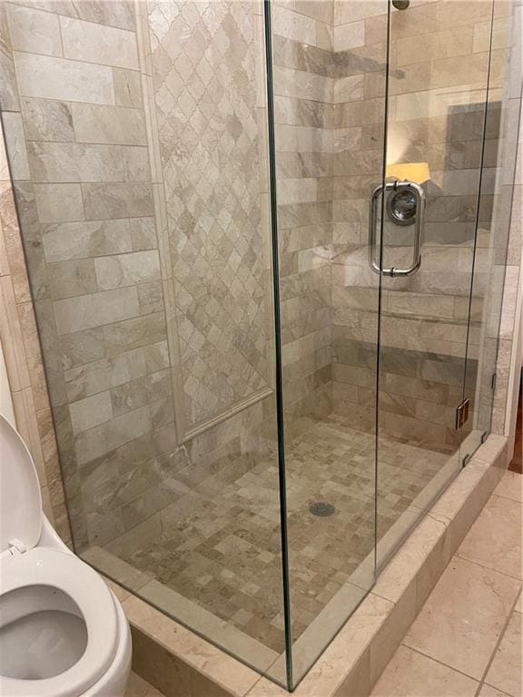 bathroom featuring tile flooring, an enclosed shower, and toilet