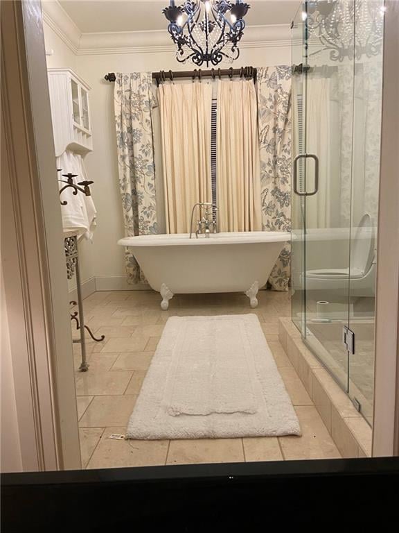 bathroom featuring a notable chandelier, ornamental molding, tile floors, and a bathtub