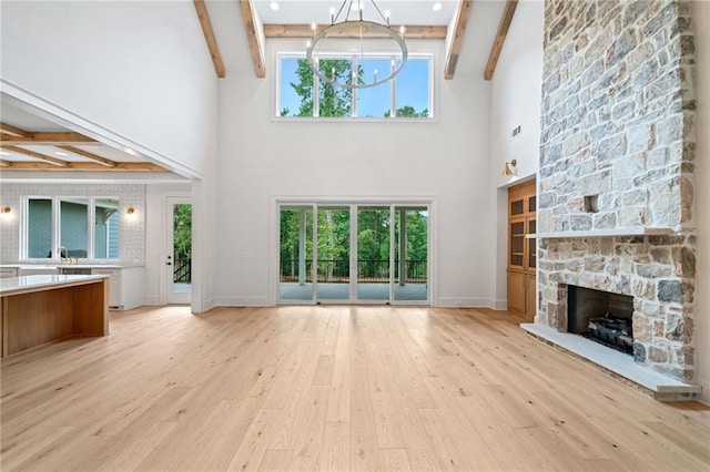 615 Claxton Ln, Milton, GA 30004 - unfurnished living room featuring beam ceiling, a chandelier, light wood-type flooring, a high ceiling, and a fireplace
