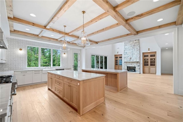 615 Claxton Ln, Milton, GA 30004 - kitchen with a center island, coffered ceiling, stainless steel gas range oven, light wood finished floors, and a fireplace