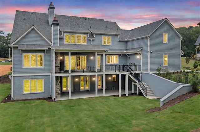 615 Claxton Ln, Milton, GA 30004 - back of house at dusk featuring a patio, a lawn, stairs, and a chimney