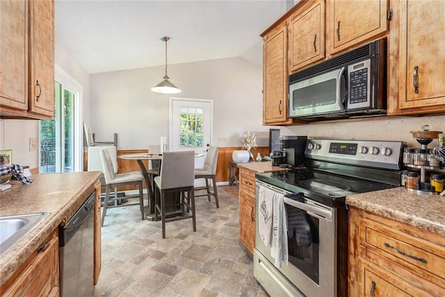 kitchen with lofted ceiling, decorative light fixtures, and stainless steel appliances