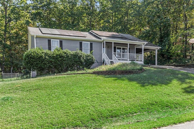 view of front of home with solar panels, a front lawn, and a porch